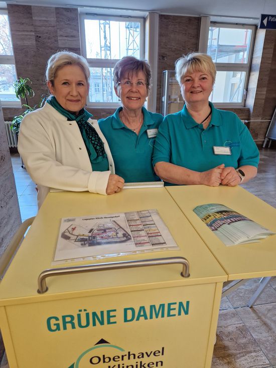 Edelgard Walter (M.) zusammen mit den Grünen Damen Elke Hartmann (l.) und Jutta Freer (r.) beim Lotsendienst in der Klinik Hennigsdorf (Foto: Oberhavel Kliniken GmbH).