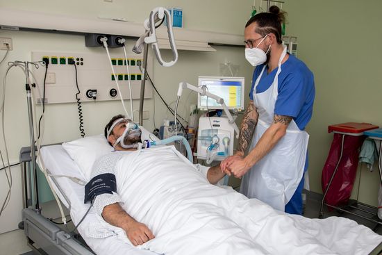 Pfleger steht am Bett eines Patienten auf der Intensivstation (Foto: Oberhavel Kliniken/C. Libuda)