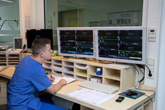 Bild von einem Pfleger, der Monitore auf der Intensivstation überwacht (Foto: Oberhavel Kliniken/C. Libuda)